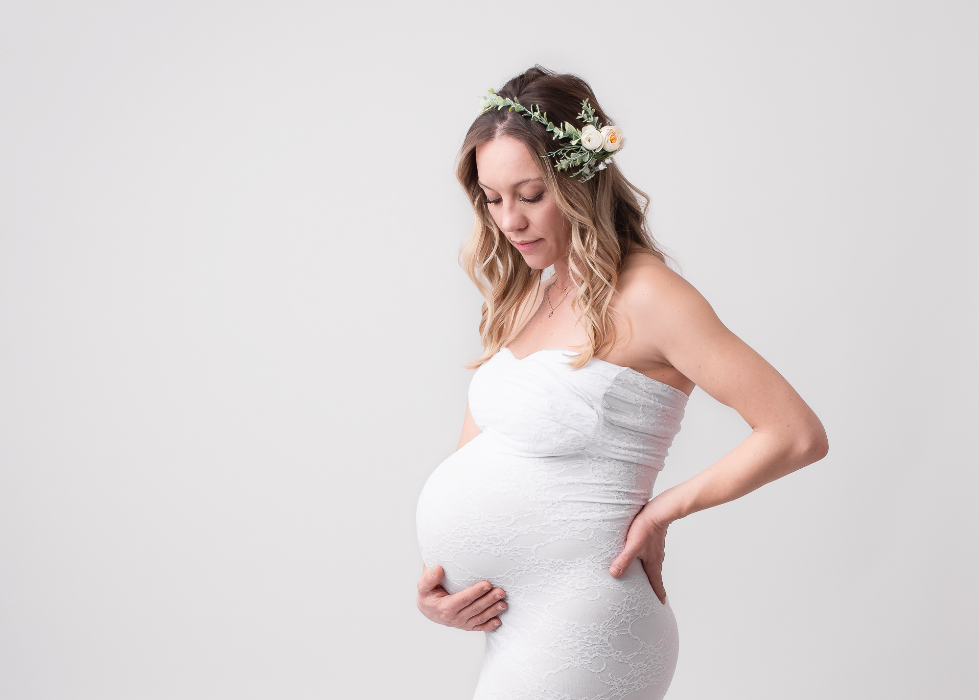 Mom to be in a white maternity gown and flower crown Medford Women’s Clinic