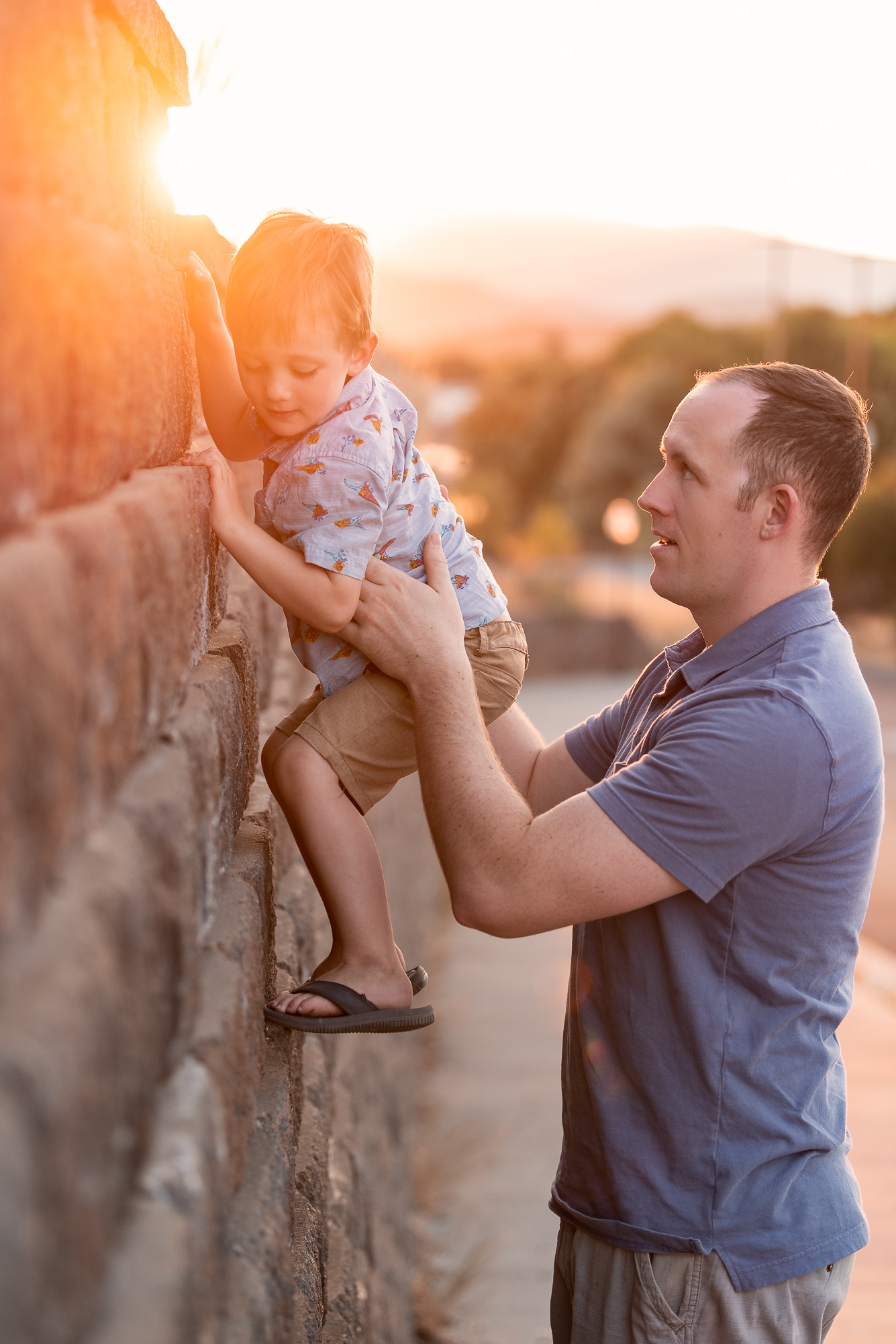 Child climbing a wall with help from his father Things to Do in Bend