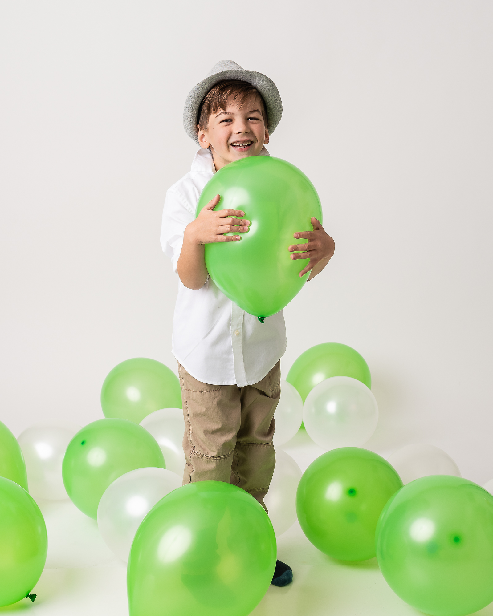 kid playing with balloons in a studio