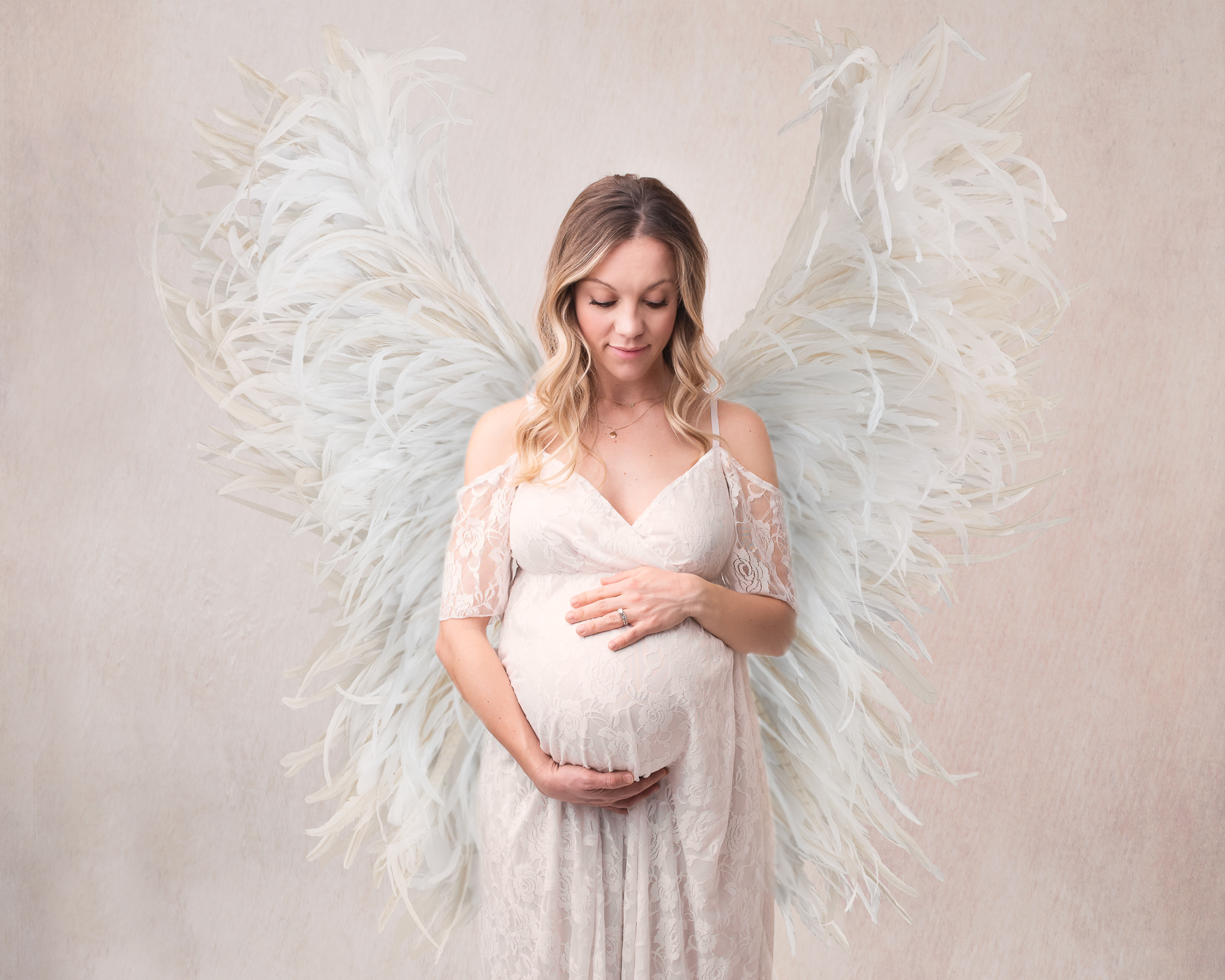 mom to be in white maternity gown and angel wings Cloud Massage Company