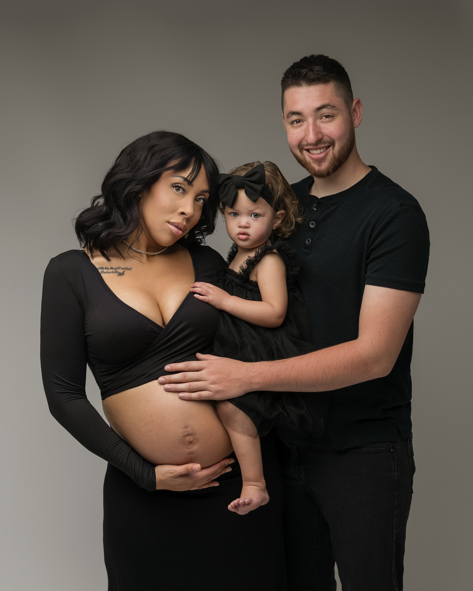 pregnant mom and family in black holding her bump Klamath Falls Birth Center