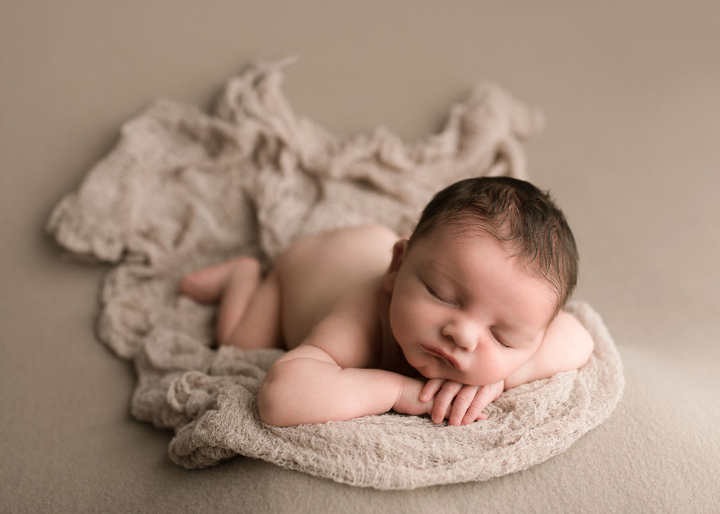 Newborn baby laying on a tan blanket sleeping Klamath Falls Birth Center