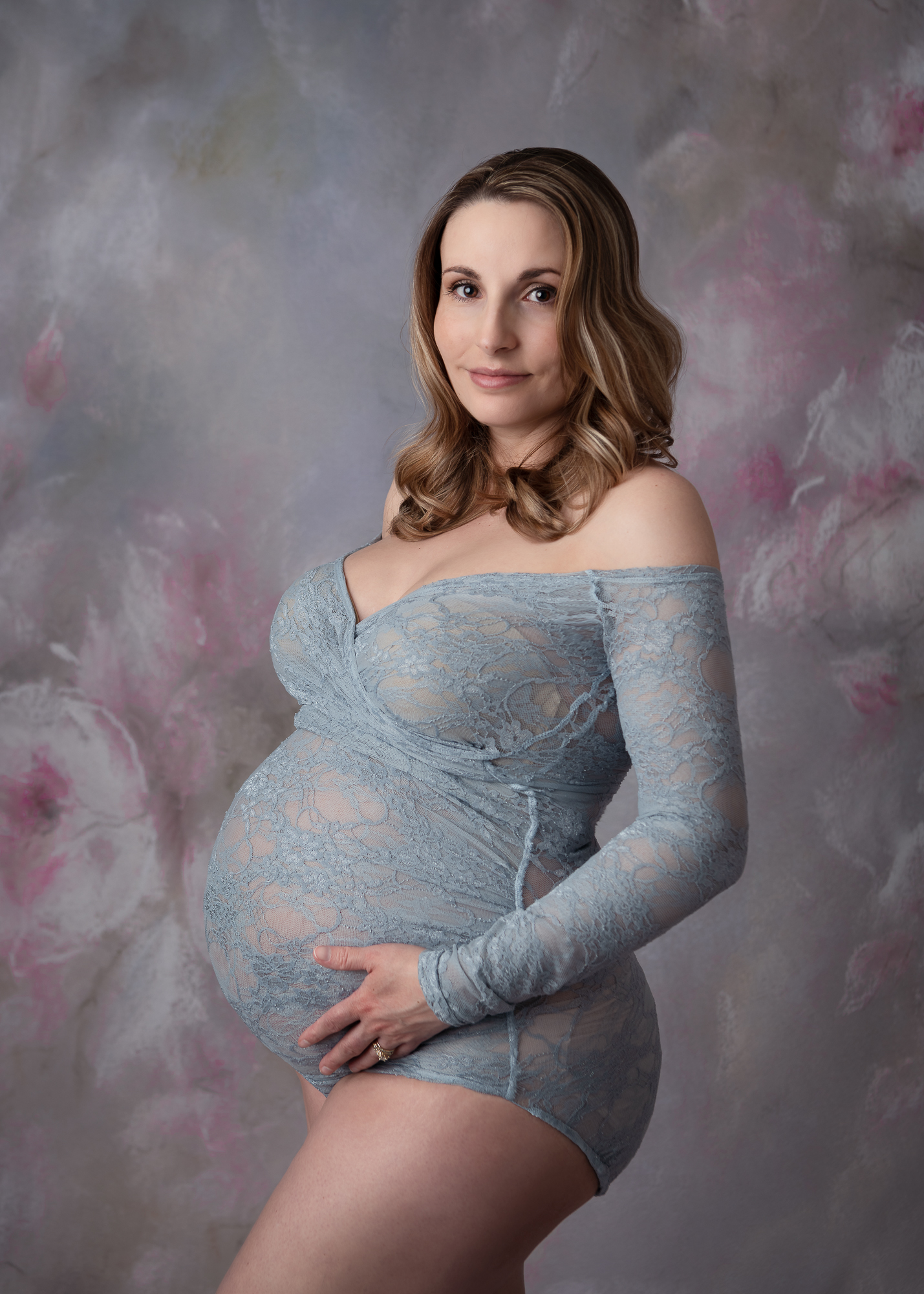 mom to be in grey long sleeve body suit holding her bump Mandala Midwifery