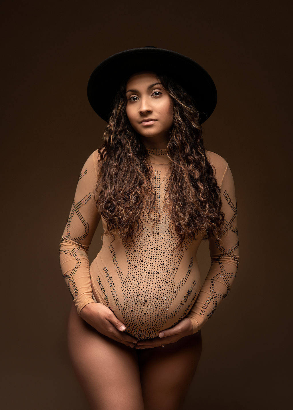 mom to be in sequenced bodysuit with black hat Organic Elements Spa Medford
