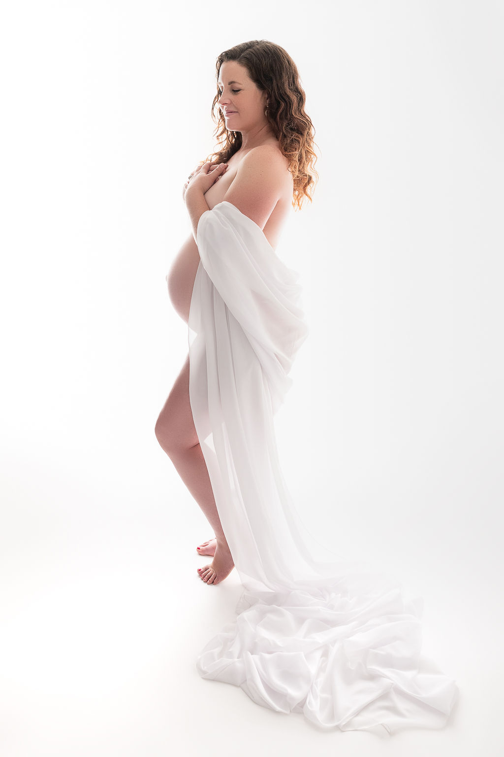 pregnant woman wrapped in a white sheet exposing her bump Siskiyou Vital Medicine