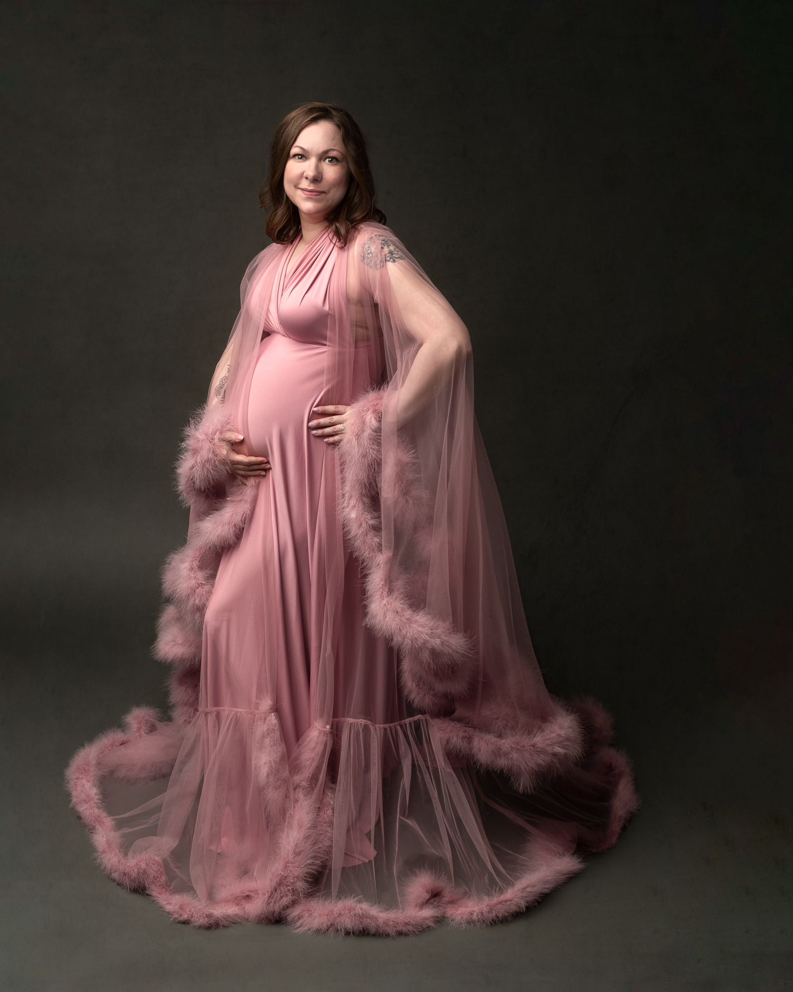Pregnant woman in pink maternity gown with her hand on her bump Sky Lakes Women's Health Clinic