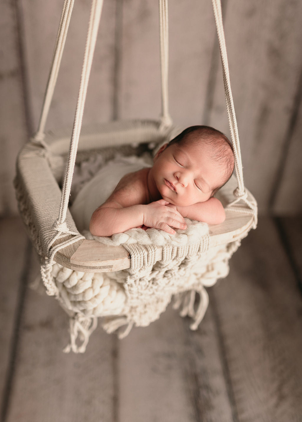 newborn baby laying on it's hands in a swing Dr. Cherry Klamath Falls