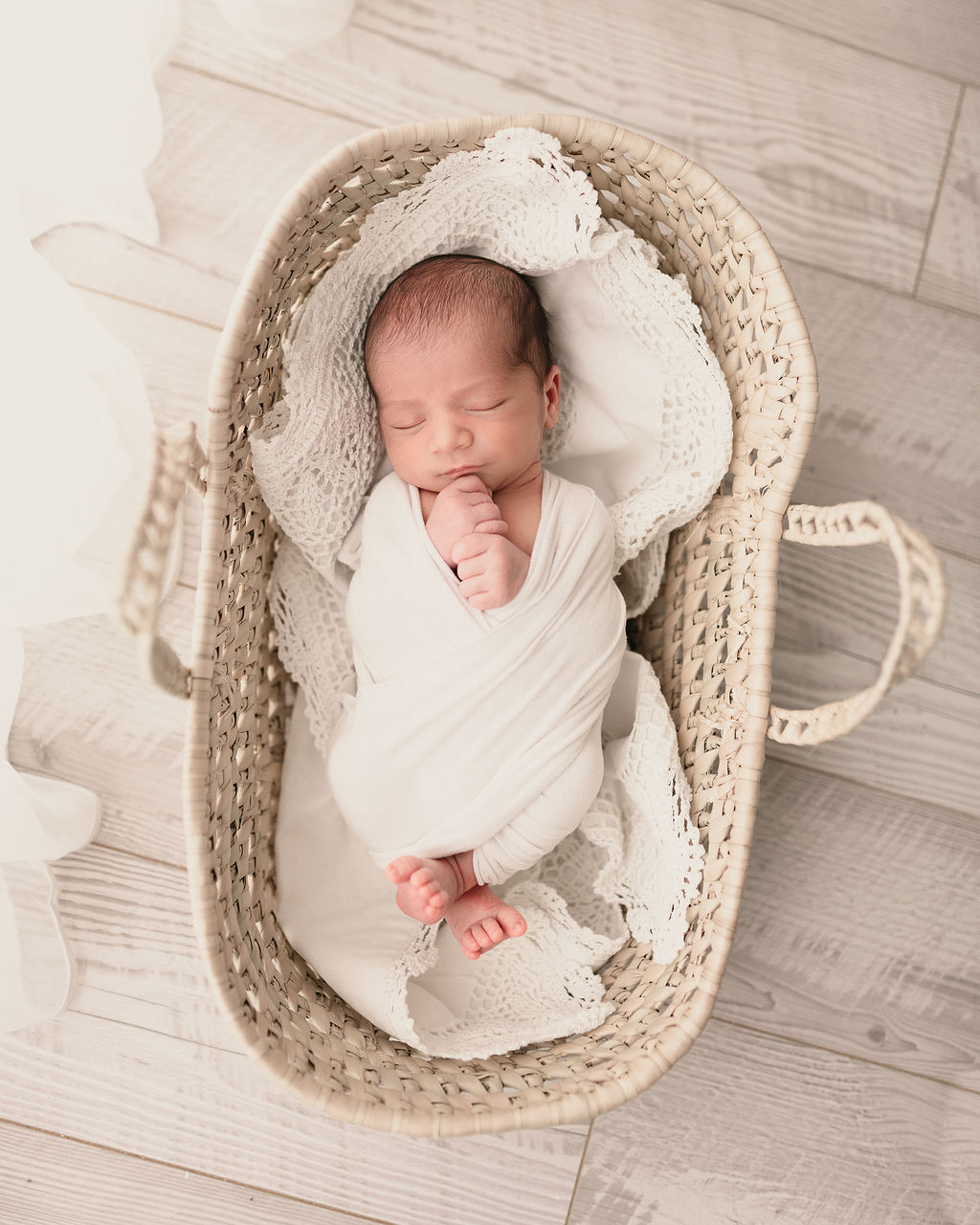 Newborn baby wrapped in cream laying in a woven basket Dr. Cherry Klamath Falls