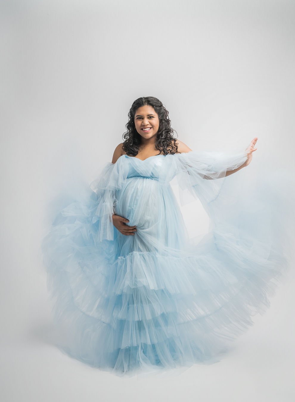 pregnant woman in blue tulle gown with her train flying East Cascade Women's Group