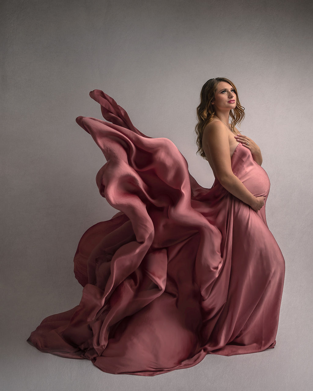 mom to be in a dark pink gown with her train flying Midwife Ashland Oregon
