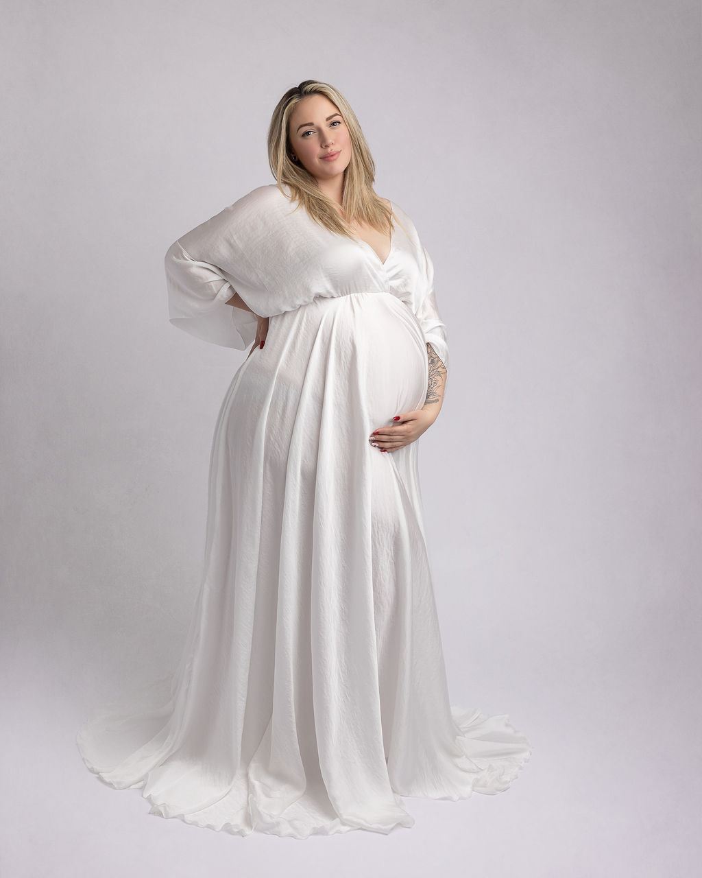 mom to be in white maternity gown cradling her bump St. Charles Birthing Center